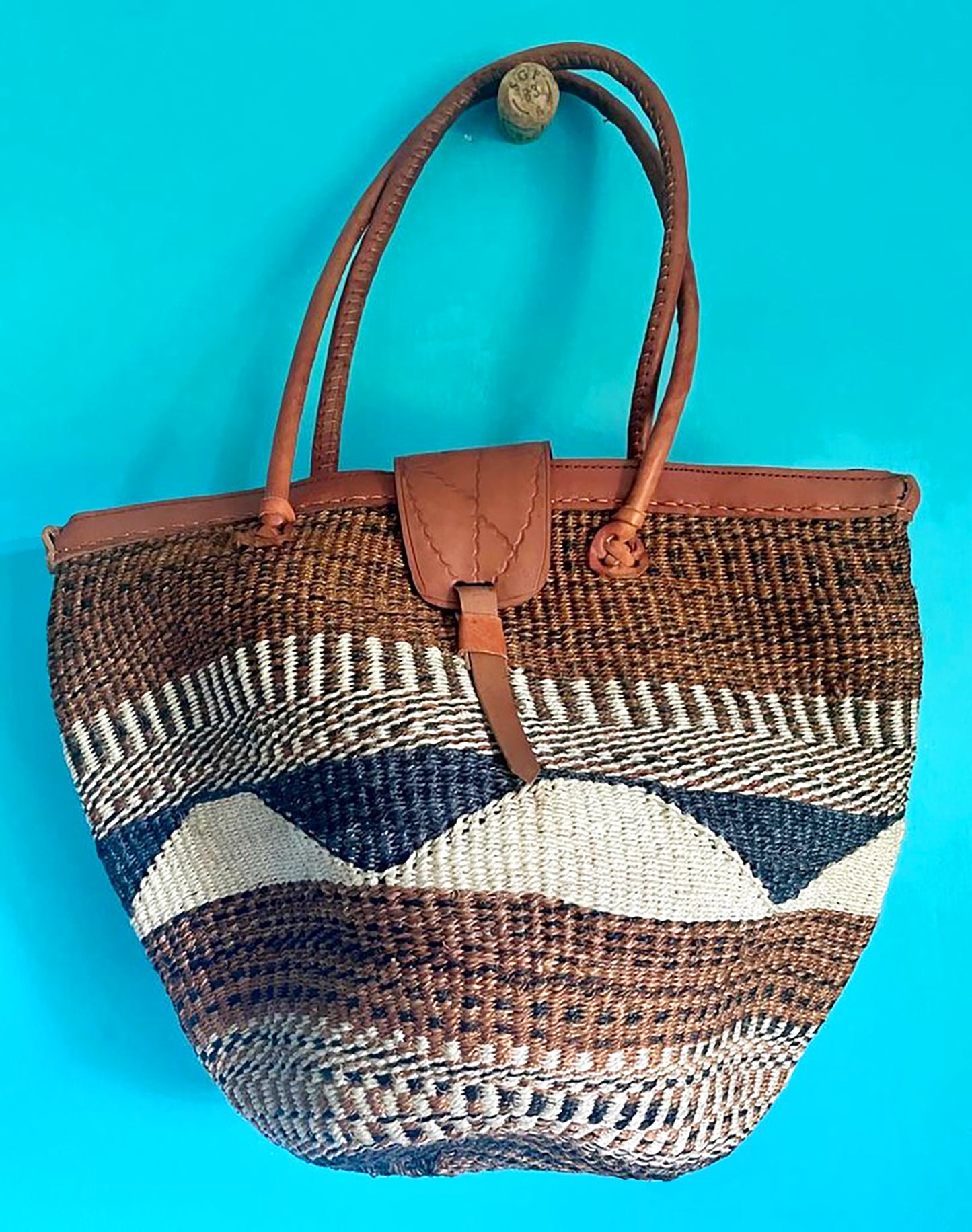 These hand woven sisal bags from Kenya are made by generations of women artisans, who have learned the art of weaving from their mothers and grandmothers. Sustainably sourced sisal fibre, natural dyes, and highest quality vegetable tanned leather, create a beautiful blend of Kenyan culture and artistry. Each bag has it's authentic, one-of-a-kind style, and is the perfect accessory for the summer. Dimensions: 17w x 14h Made in Kenya