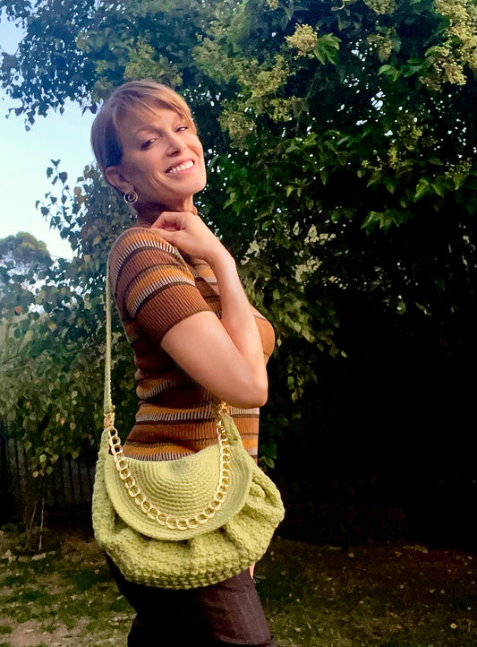 A homage to the 70's style of the iconic Goldie Hawn, this vintage cross body, crocheted bag is two bags in one. Adjustable strap can be tucked inside, which then turns the gold chain accent into a chic handle for a more dressy look. Hand crocheted with upcycled acrylic yarn by Oda G. exclusively for MarVia Square. Dimensions: Height: 21" Length: 13" Width: 4" Hand wash cold Made in California