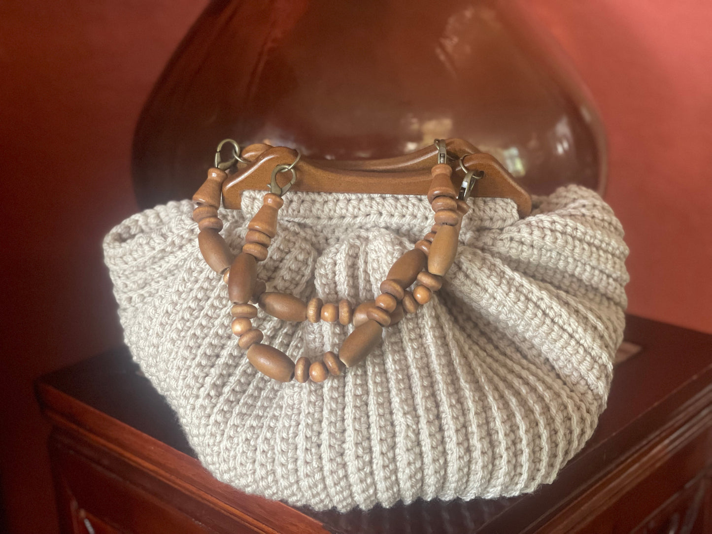 Malibu lifestyle best describes this Boho chic, hand crocheted bag. One-of-a-kind, reflecting Malibu's beautiful sandy beaches with up cycled, cotton blend yarn and wood beaded handles that are removable to create a clutch style. Bag Dimensions: 12"wide x 9"high (Handles: 5"wide x 5"high) Color: Sand Consciously crafted in California