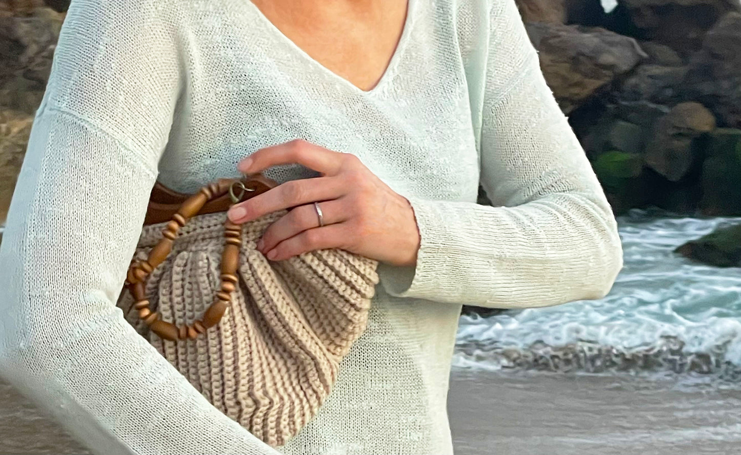 Malibu lifestyle best describes this Boho chic, hand crocheted bag. One-of-a-kind, reflecting Malibu's beautiful sandy beaches with up cycled, cotton blend yarn and wood beaded handles that are removable to create a clutch style. Bag Dimensions: 12"wide x 9"high (Handles: 5"wide x 5"high) Color: Sand Consciously crafted in California